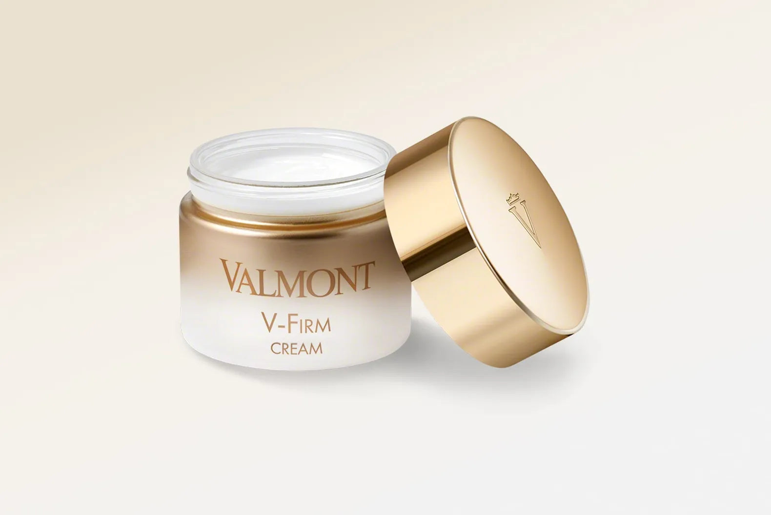 Valmont V-Firm Cream jar with gold lid on a light beige background