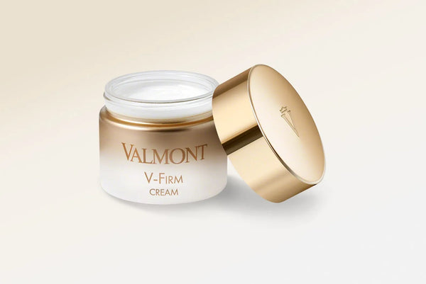 Valmont V-Firm Cream jar with gold lid on a light beige background