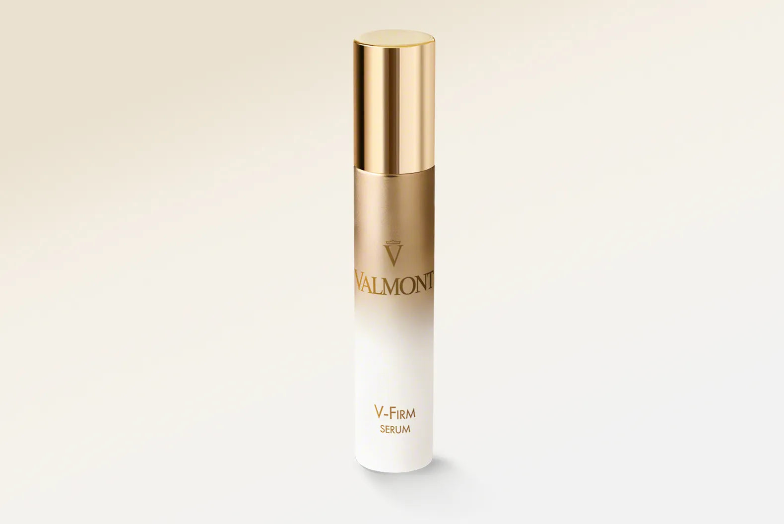 Skincare serum bottle with gold cap and white body on a light beige background